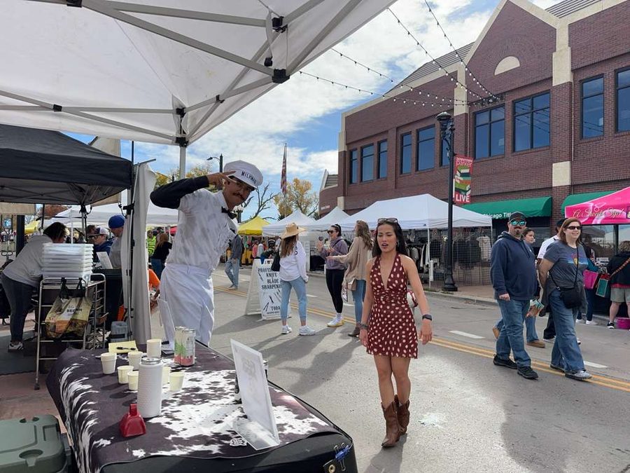 The Fizzy Moo tent at a street market in Boulder, with the milkman pouring samples