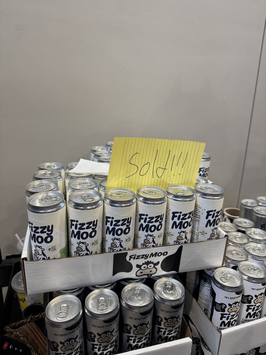 A box of Fizzy Moo cans with a handwritten Sold sign on it